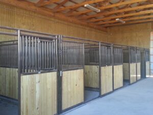 Horse stables with wooden and metal stalls inside a barn